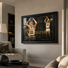 Larry Bird wall art in black frame displayed in a premium living room above a neutral sofa and warm wall.