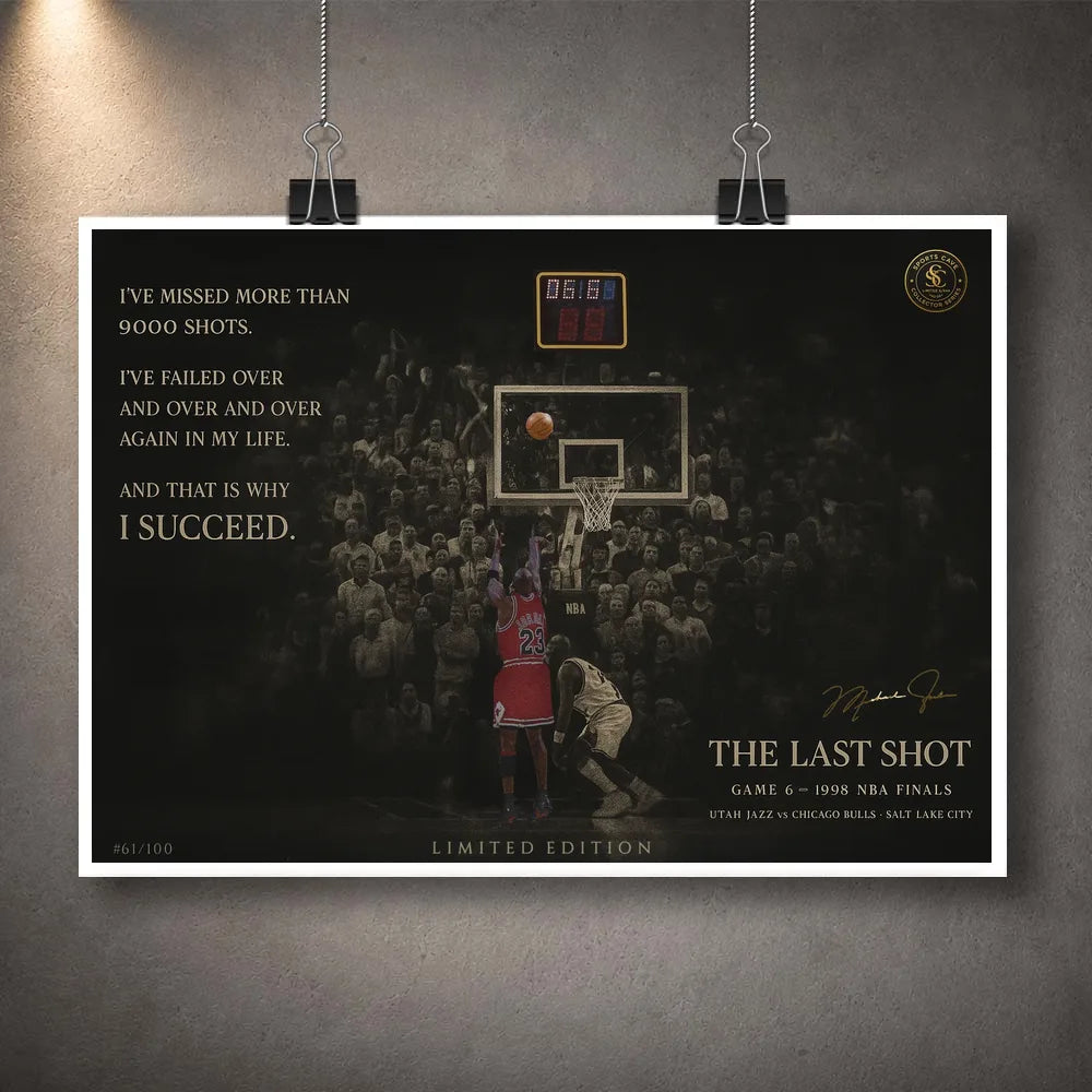 Last shot basketball print hanging from clips on a grey wall.