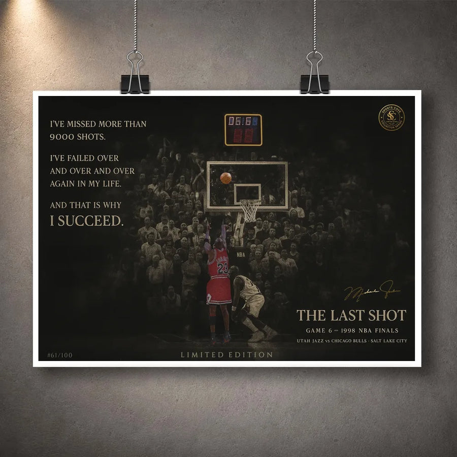 Last shot basketball print hanging from clips on a grey wall.
