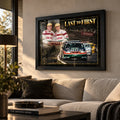 Last to First motorsport wall art displayed above a neutral living room sofa in a black frame with warm natural light.