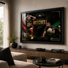 Black framed Latrell Mitchell wall art displayed above a timber console in a bright modern living room.