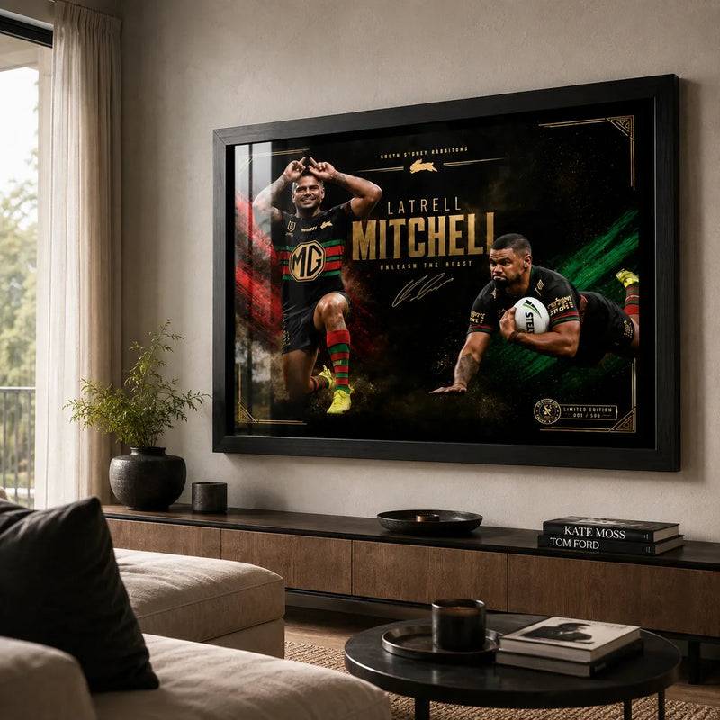 Black framed Latrell Mitchell wall art displayed above a timber console in a bright modern living room.