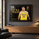 Luka Doncic Luka Magic edition in a black frame above a timber sideboard in a dark man cave with a leather chair.