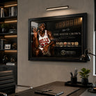 Michael Jordan wall art mounted in a modern office above a desk, shown in a black frame with focused wall lighting.