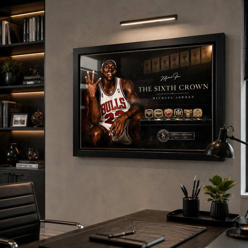 Michael Jordan wall art mounted in a modern office above a desk, shown in a black frame with focused wall lighting.