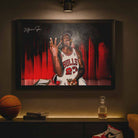 Framed Michael Jordan wall art on a dark wall under a spotlight—Bulls jersey, cigar celebration—premium framed sports art mockup for man cave wall décor.
