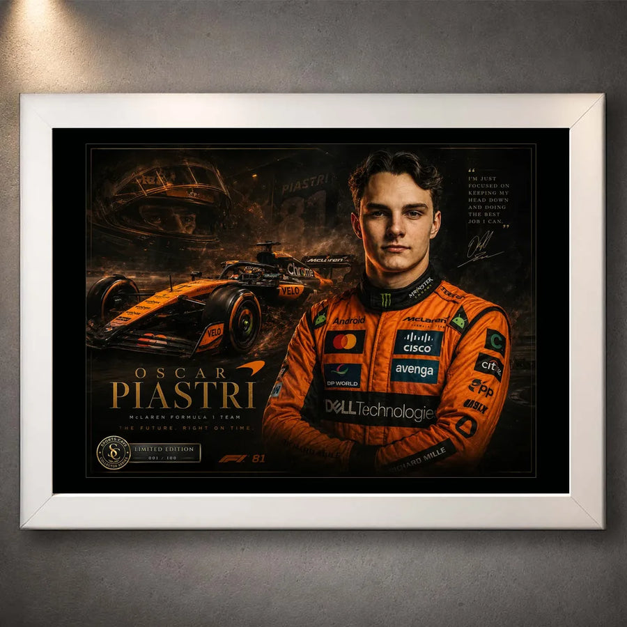 Motorsport wall art in a white frame, showing orange racing artwork and portrait on a grey wall.