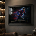 Neymar Jr Barcelona wall art in a black frame on a dark man cave wall with shelves and leather seating.