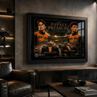 Black framed Piastri vs Norris motorsport wall art displayed in a dark man cave with leather seating.