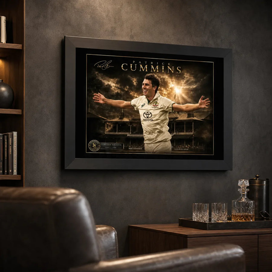 Pat Cummins framed cricket wall art displayed on a dark man cave wall beside leather seating and a drinks cabinet.