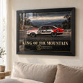 Peter Brock King of the Mountain wall art in a bright living room, displayed in a black frame above a neutral sofa.