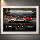Peter Brock King of the Mountain wall art in a white frame, with gold title lettering and a red and white racing car.