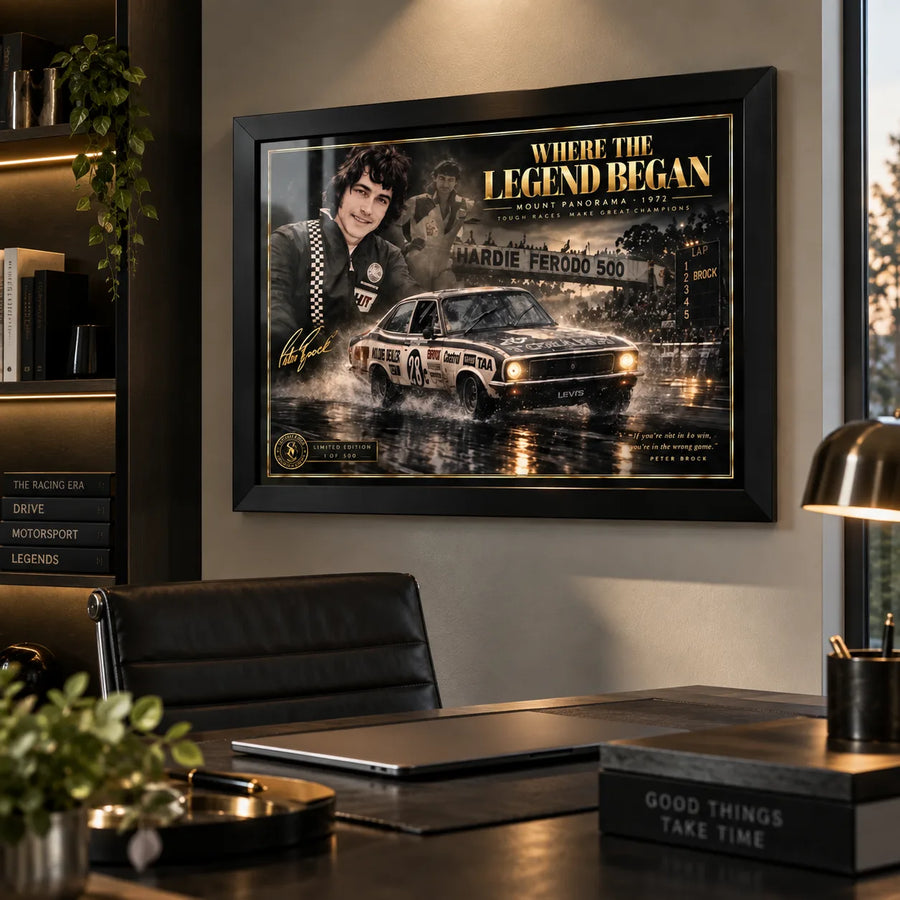 Peter Brock wall art displayed above a desk in a modern office, styled in a black frame for a motorsport collector space.