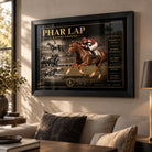 Black framed Phar Lap horse racing wall art displayed in a warm living room above a neutral sofa beside a floor lamp.