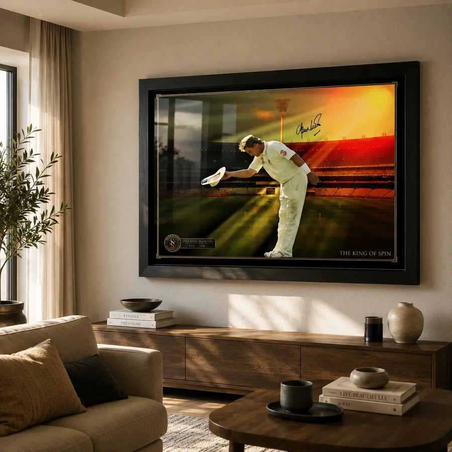 Shane Warne cricket wall art in a black frame displayed on a warm beige living room wall above a timber console.
