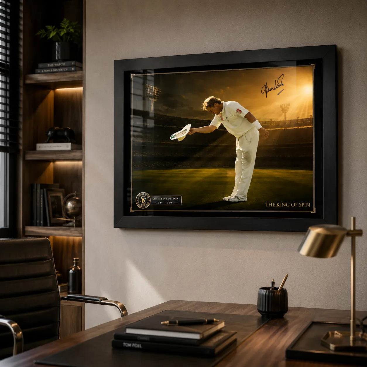 Shane Warne cricket wall art in a black frame mounted above a timber desk in a refined home office.