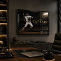 Black framed Derek Jeter The Captain baseball wall art mounted in a dark premium office above timber cabinetry.
