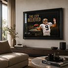 The City Believed NFL wall art displayed in a bright neutral living room with a black frame above a timber console.