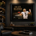The City Believed New Orleans football wall art in a dark man cave, black framed above a cabinet with football memorabilia.