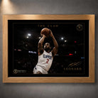 Kawhi Leonard The Claw basketball wall art in an oak frame, shown as a close-up product display on a dark grey wall.
