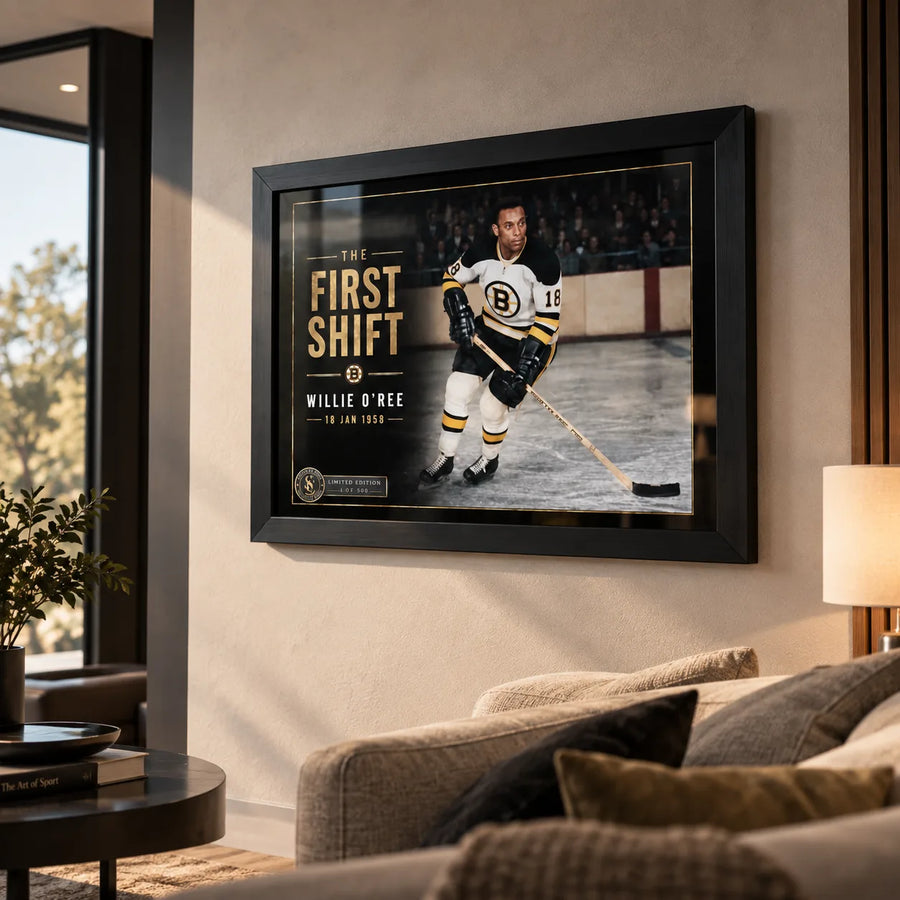 Black framed Willie O'Ree wall art displayed in a warm living room setting for hockey fans and sports art collectors.