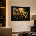 Pelé soccer wall art displayed in a warm modern living room with a black frame and subtle ambient lighting.
