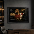 Thierry Henry Arsenal wall art in a black frame on a dark room wall with built-in shelving.