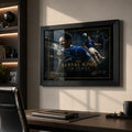 Black framed Tim Cahill Everton wall art above a desk in a premium home office with warm natural light.