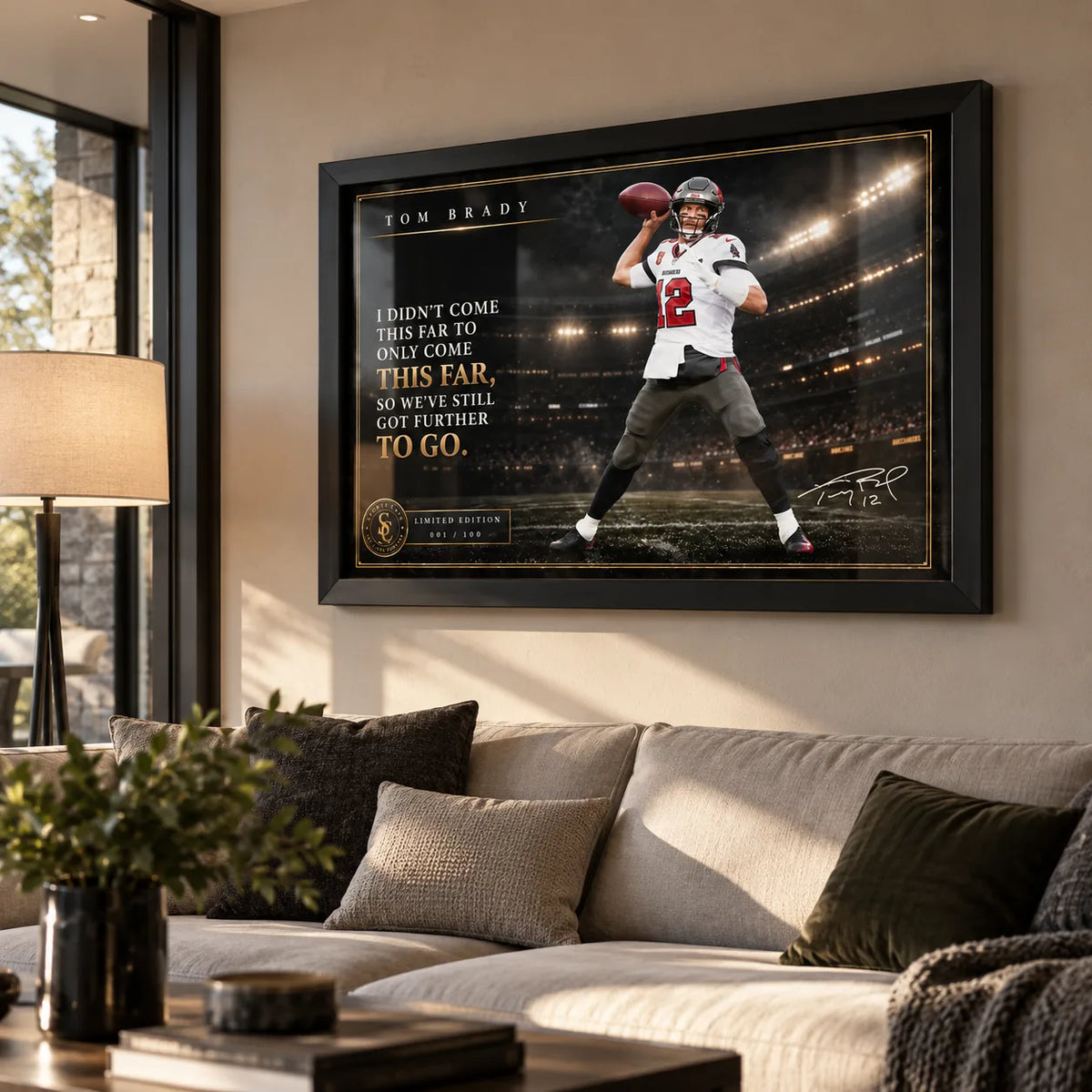 Tom Brady NFL wall art in a black frame displayed above a neutral sofa in a bright modern living room.