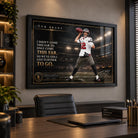 Tom Brady NFL wall art in a black frame displayed above a desk in a premium home office with warm ambient lighting.