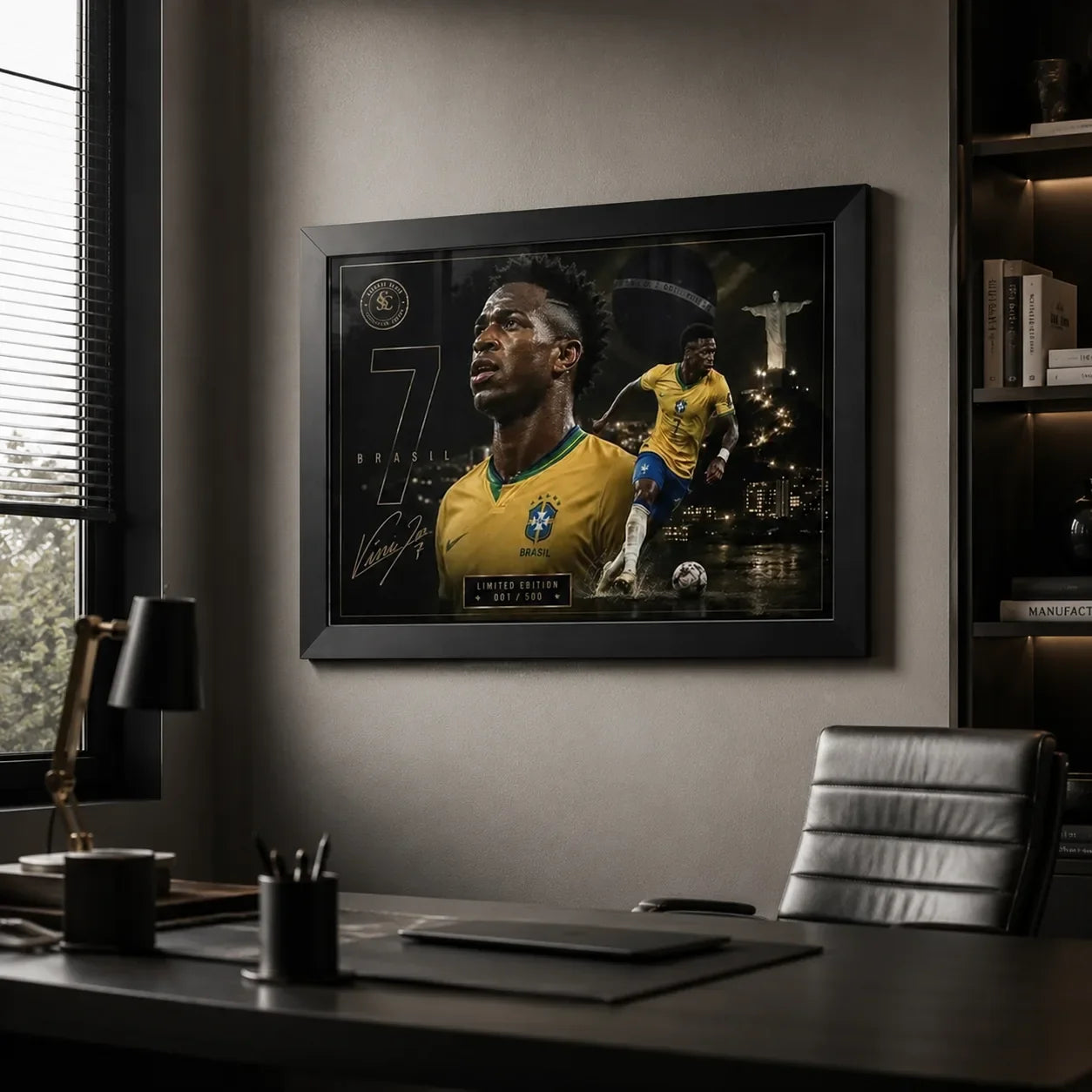 Black-framed Vinicius Junior Brazil wall art displayed in a modern office above a desk with dark shelving and window light.