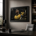 Black-framed Vinicius Junior Brazil wall art displayed in a modern office above a desk with dark shelving and window light.