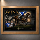 Oak framed Winx horse racing wall art featuring the champion mare and jockey in a dark gold collector design.
